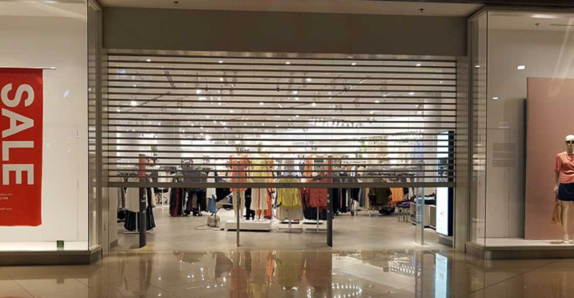 Rideau métallique transparent fermé devant la vitrine d'une boutique